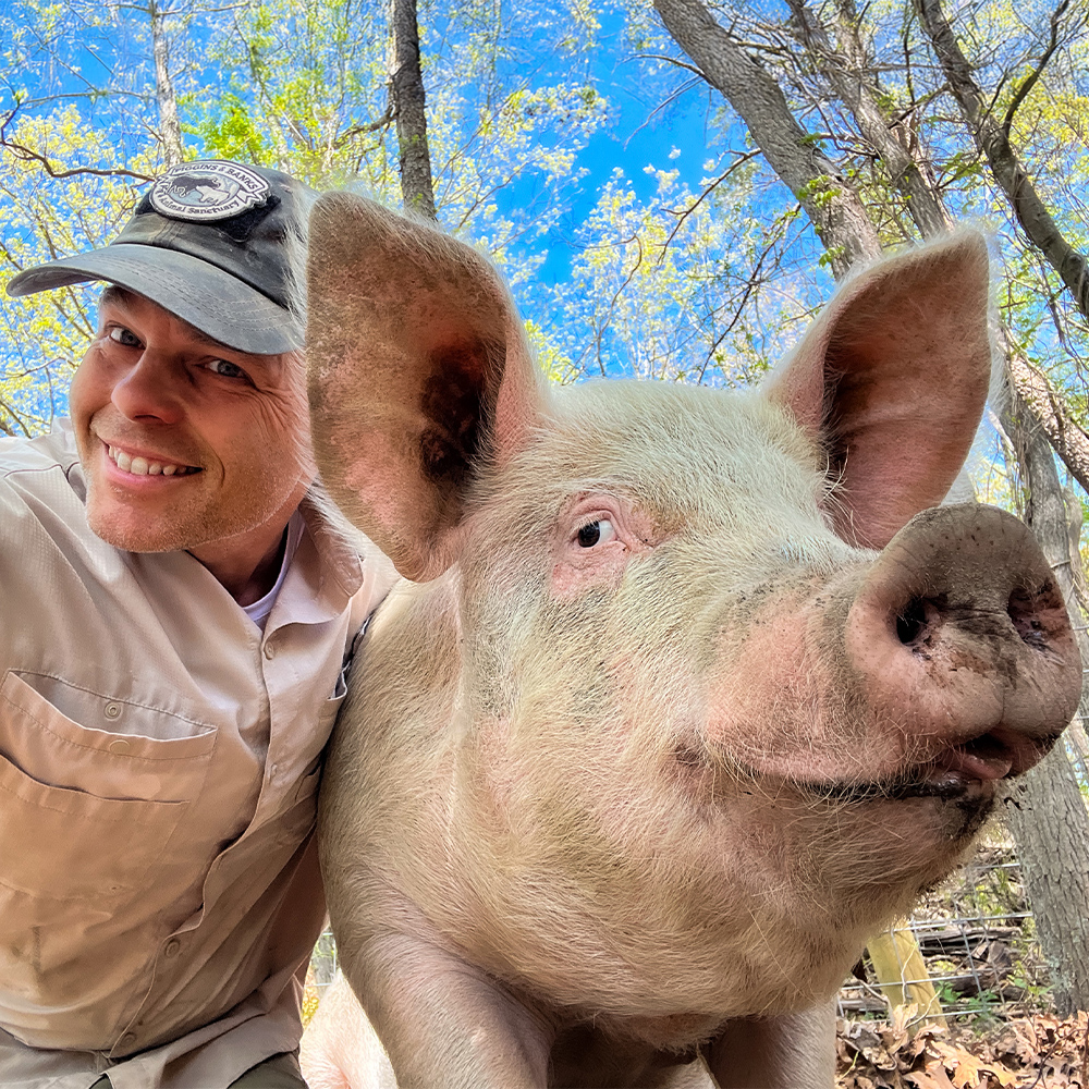 Photograph of Aaron Riddle with Georgie the pig